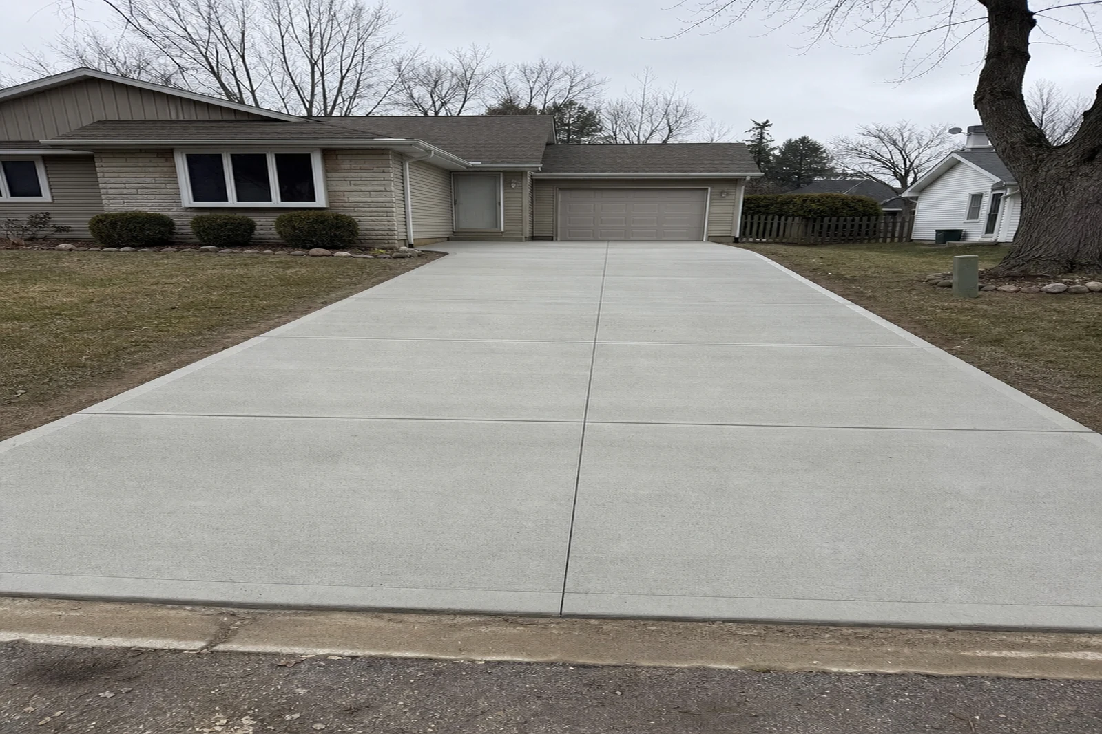 Finished broom-finished concrete driveway slab in South Bend Indiana with clean control joints and garage approach